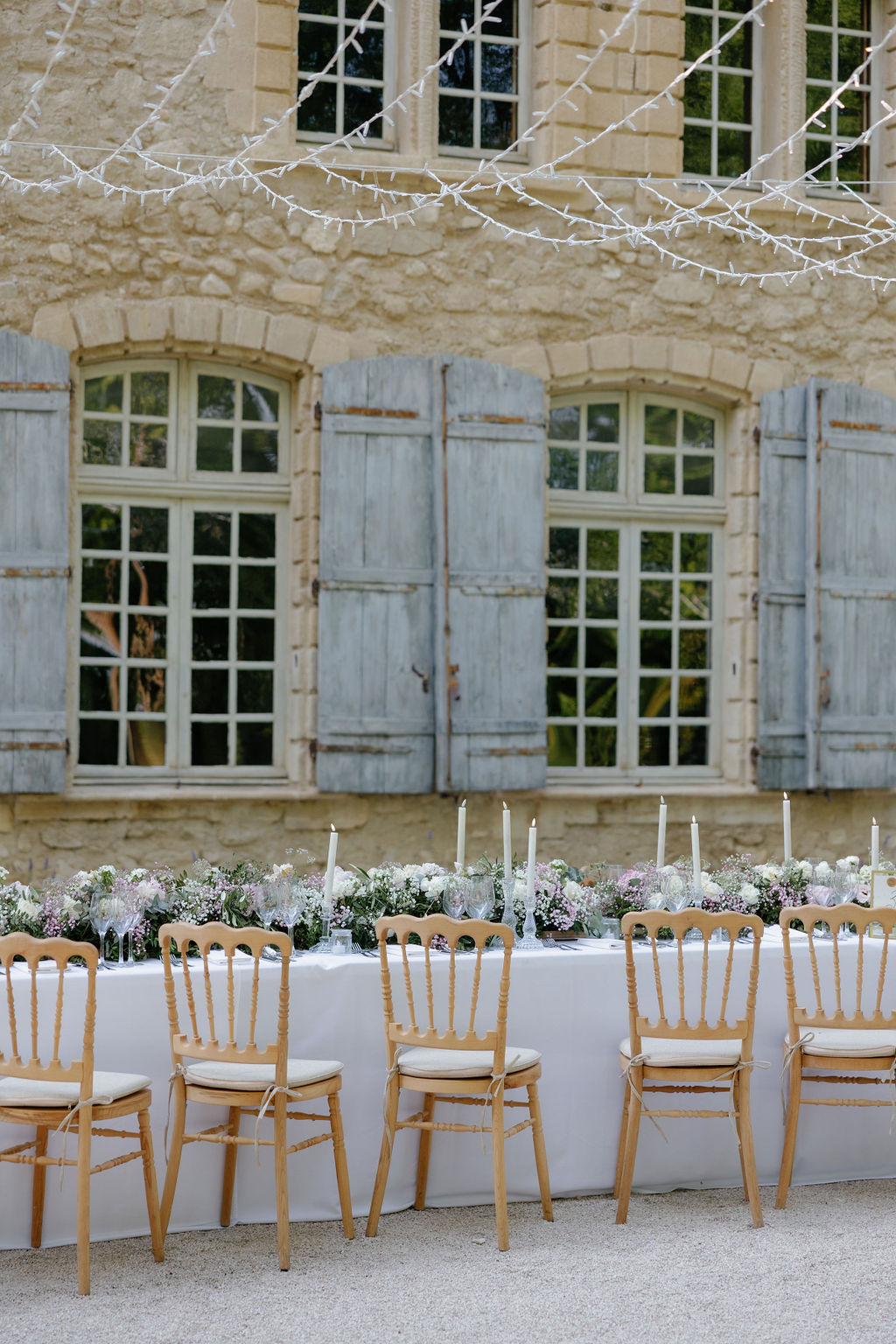 String lights hanging over elegant French chateau wedding 