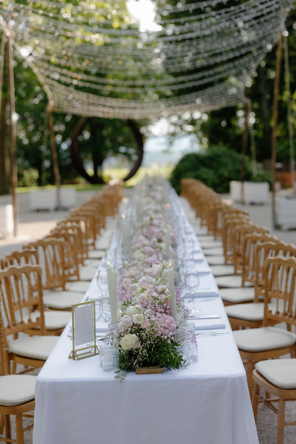 Pastel pink wedding flowers for long singular reception table 