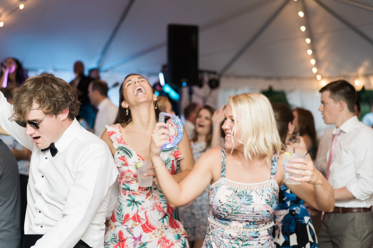 Guests shaking tambourines at wedding reception dance floor 