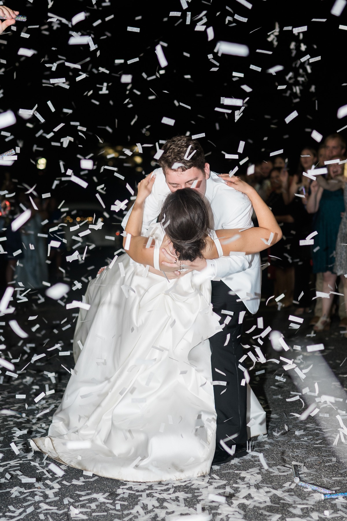 Groom dipping bride at confetti wedding exit 