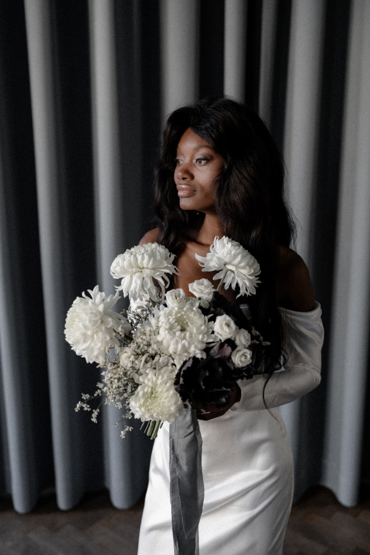 Bride in Two Souls wedding gown holding monochrome bouquet