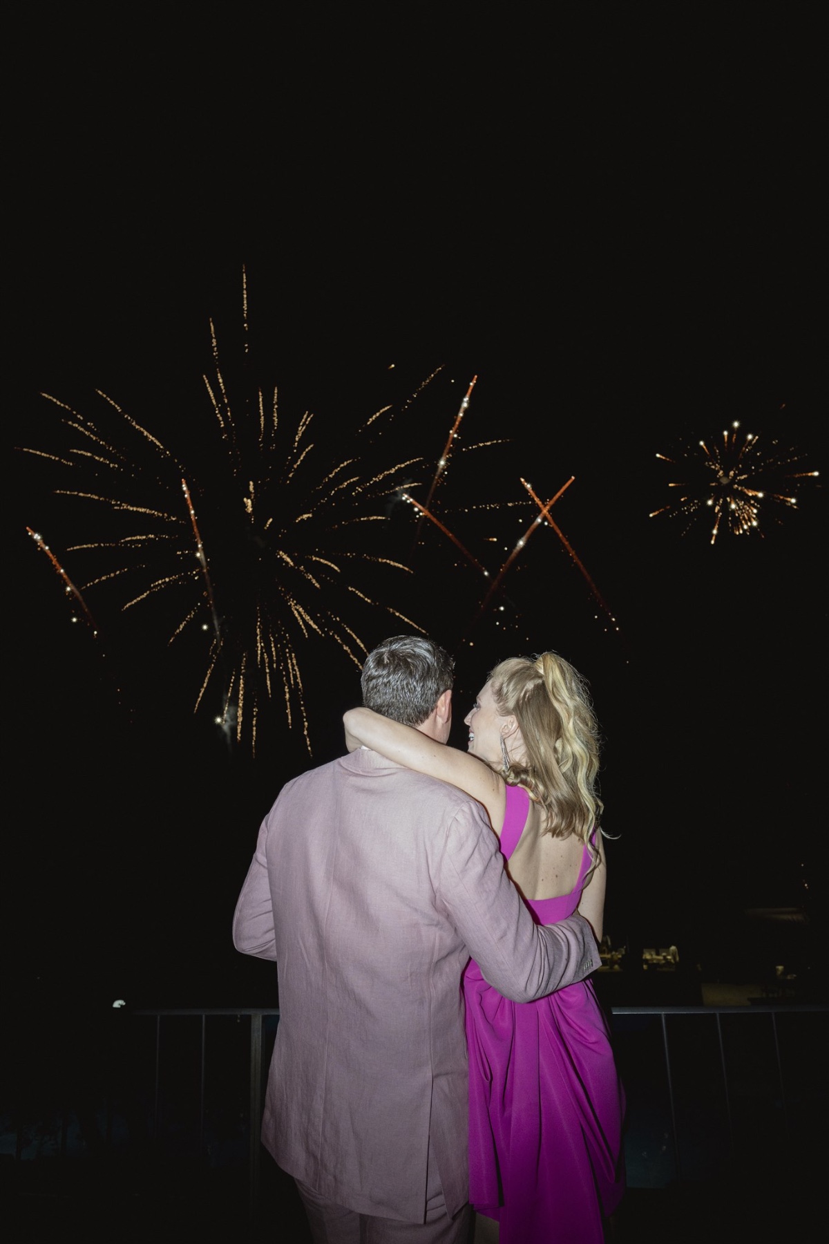 Bride and groom watching welcome party fireworks display 