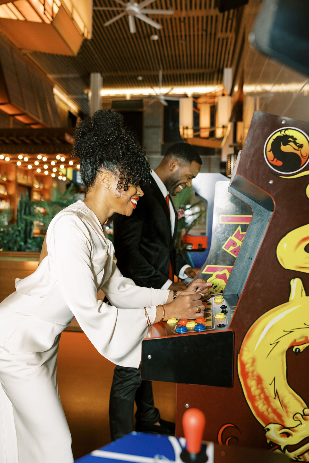 Bride and groom playing arcade games