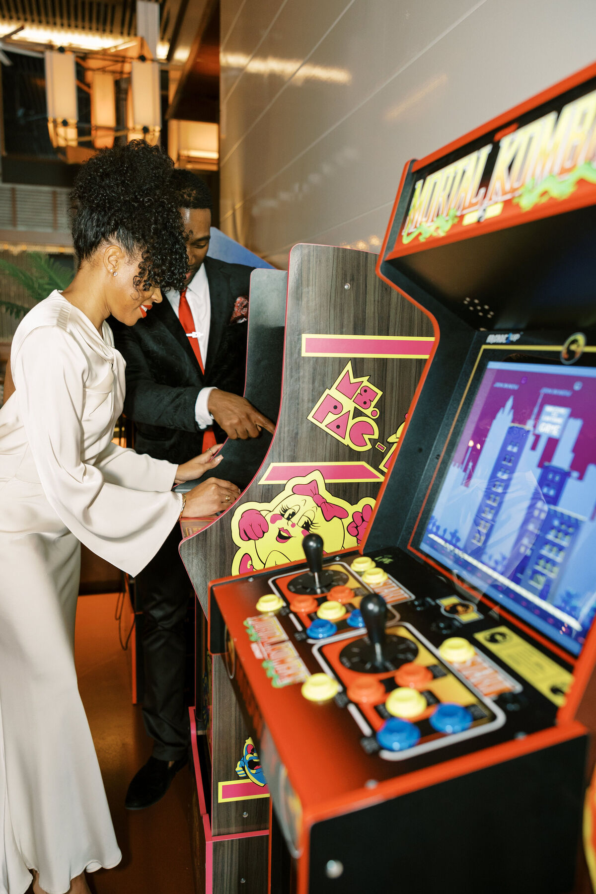 NYC couple playing arcade games after wedding 