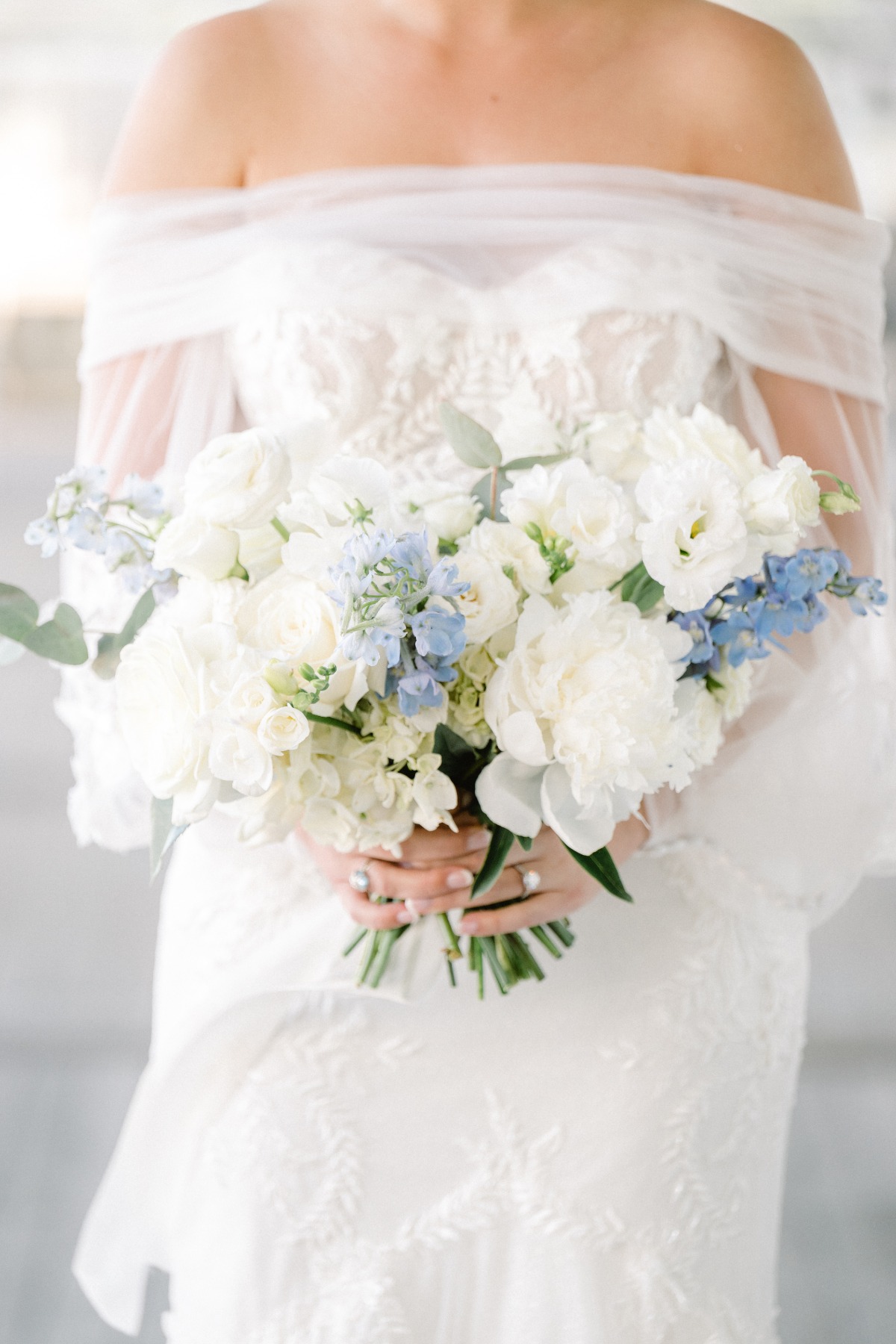 White roses, ranunculus, and delphinium bouquet for brides