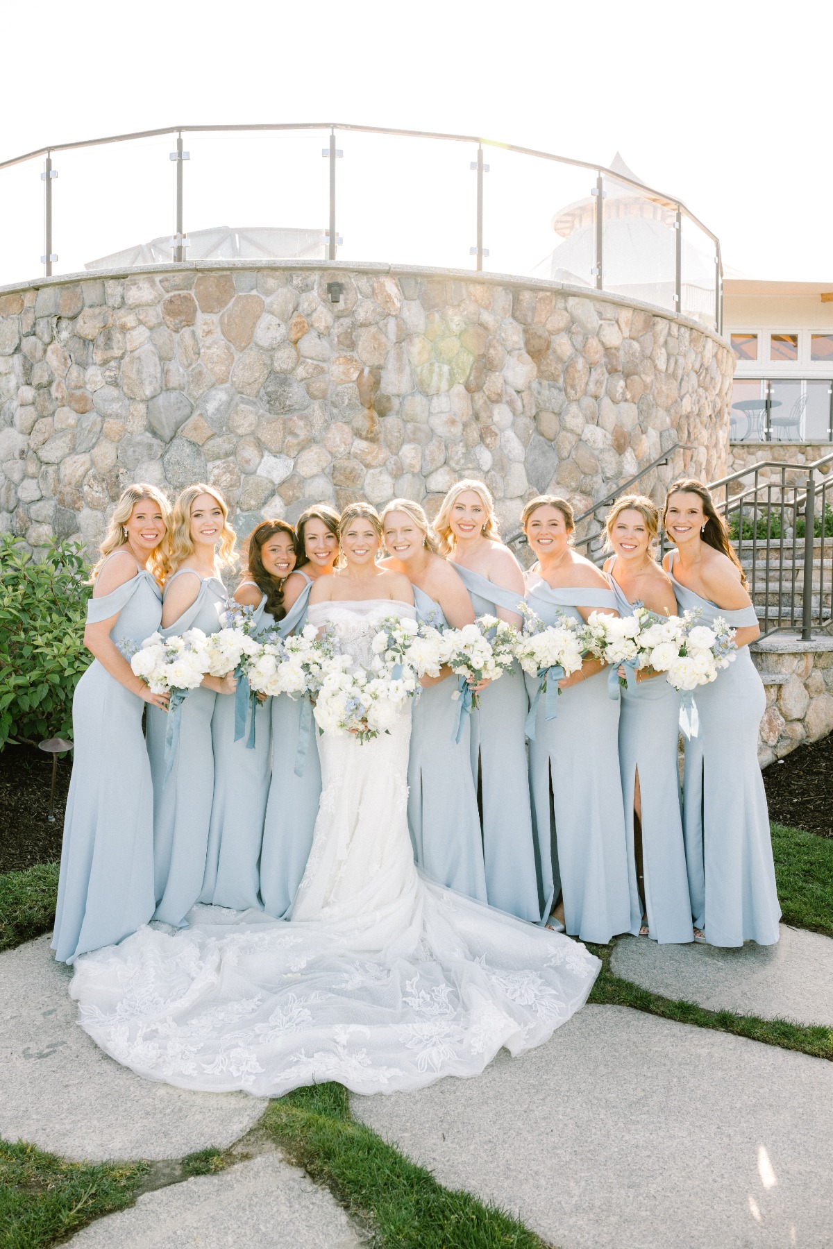 Bride in elegant lace dress with bridesmaids in pastel blue