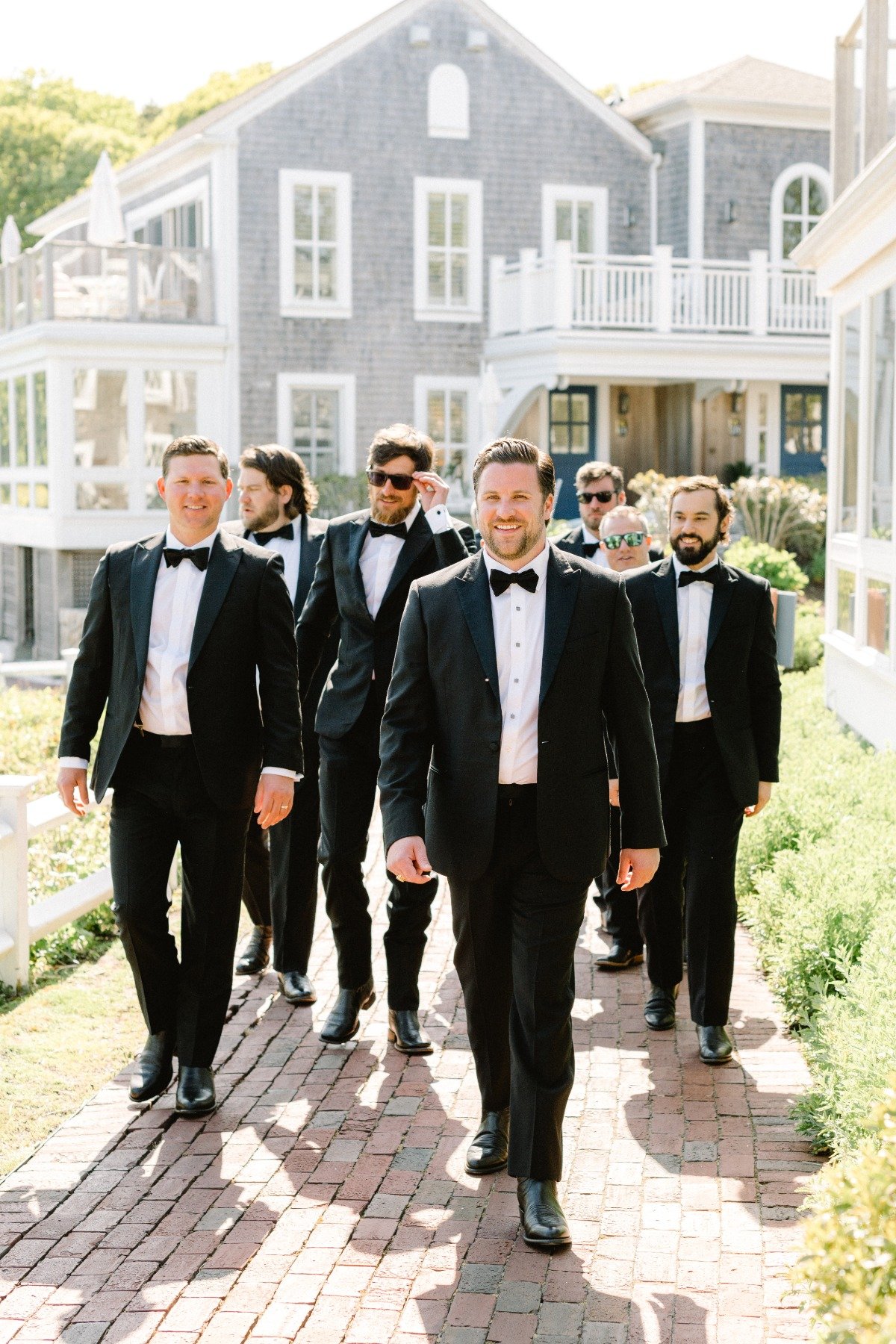 Timeless Cape Cod groomsmen in classic black and white tuxedos