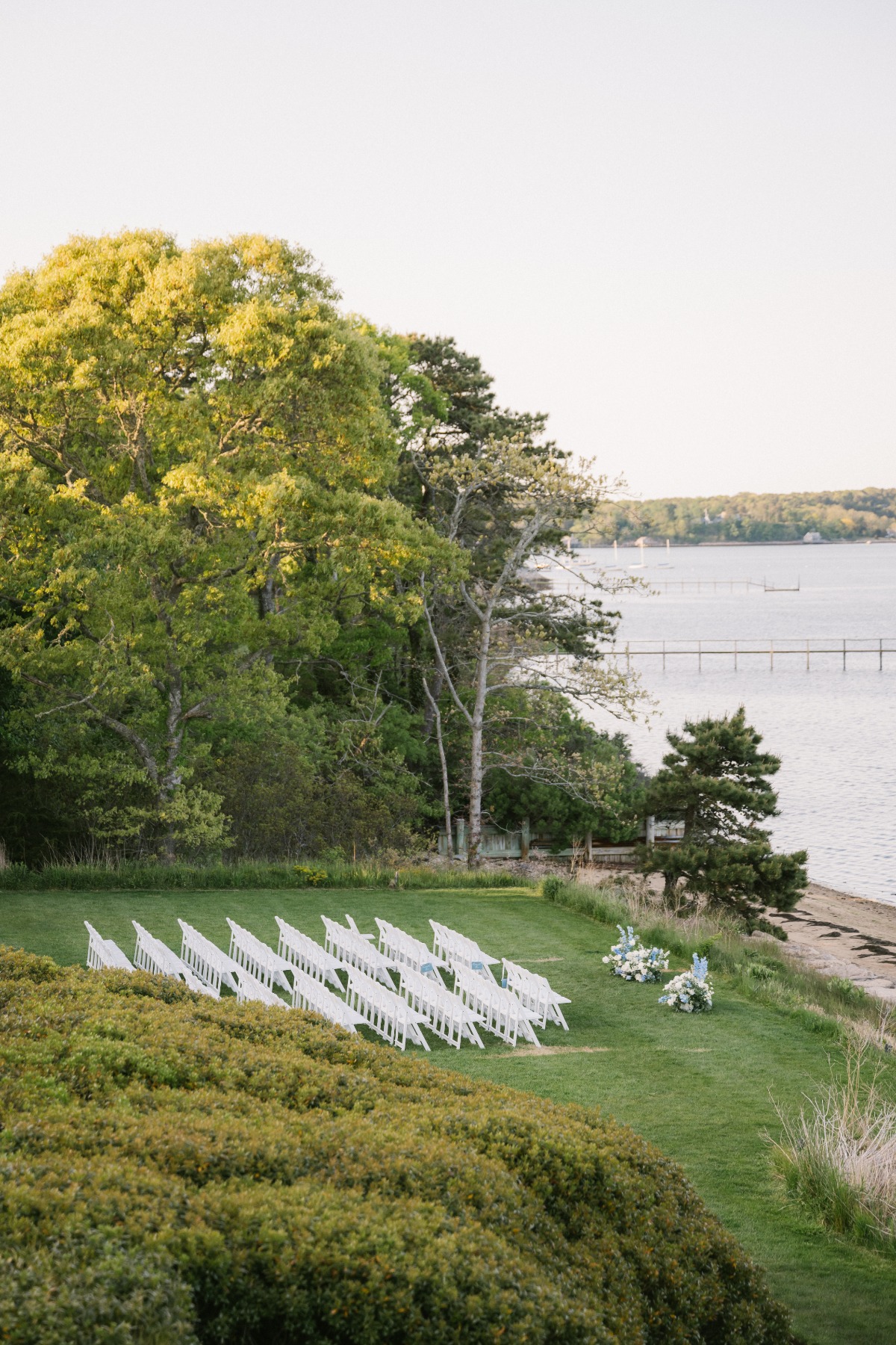 Coastal wedding ceremony with white chairs in Cape Cod