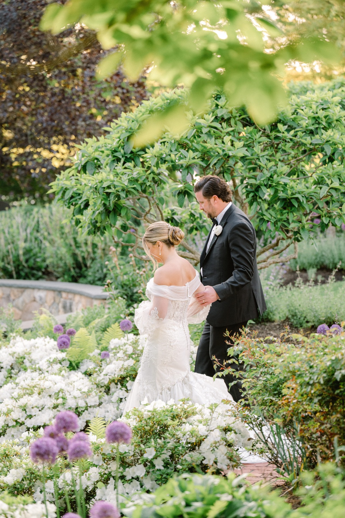 Bride and groom walking through gardens at Cape Cod venue