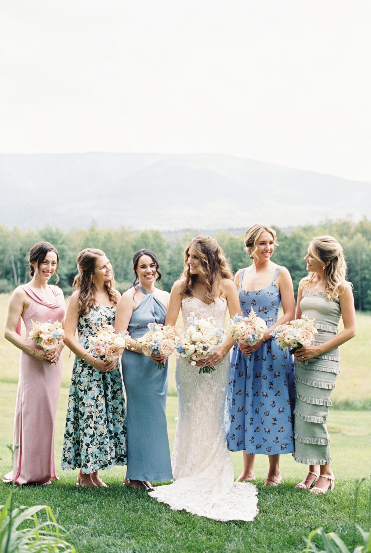 Mismatched pastel floral bridesmaids dresses and bouquets