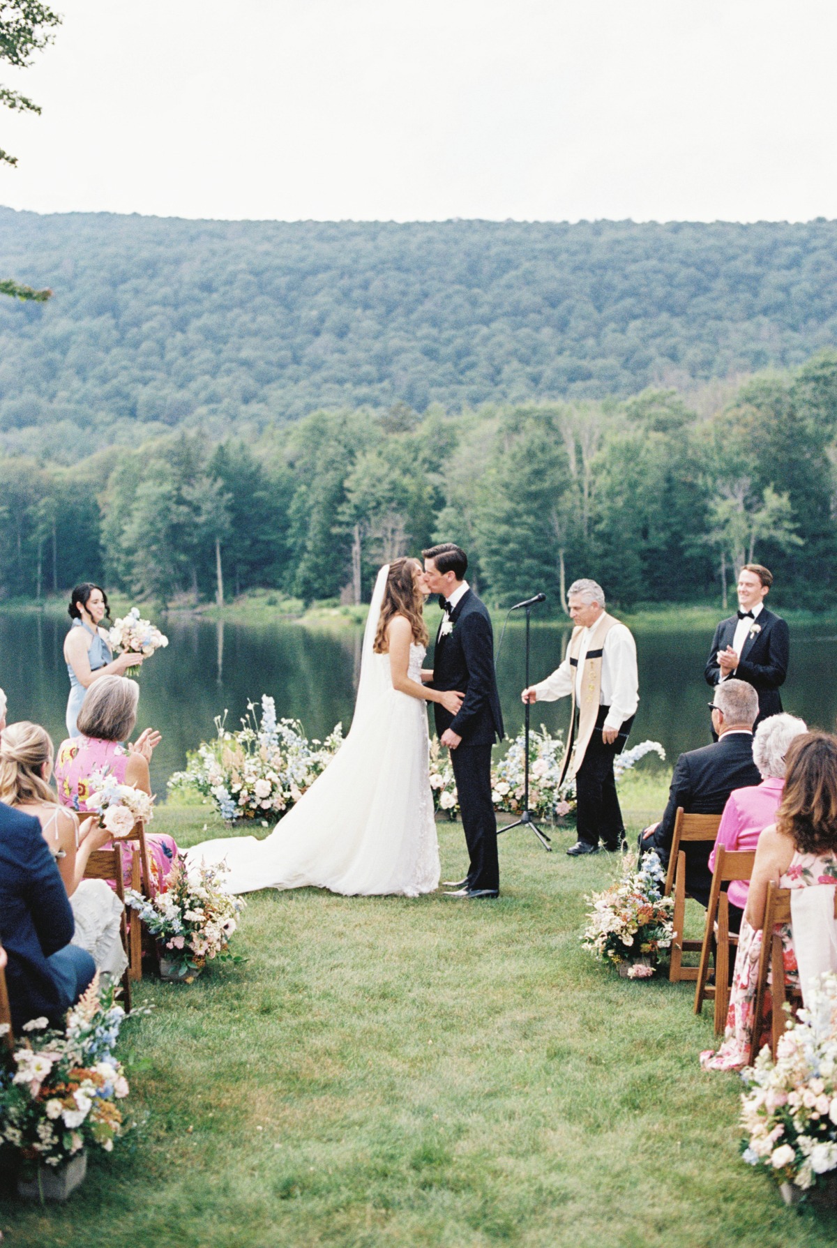 First kiss at lakeside wedding ceremony in the Catskills