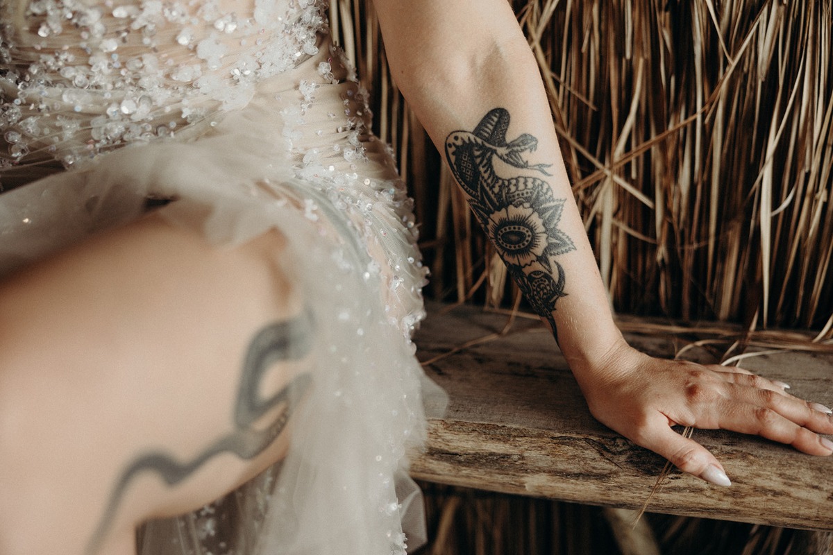 Tattooed bride sitting at bar 