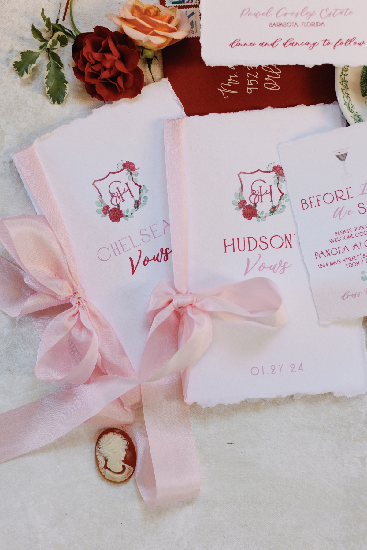 Red and white wedding invitations with pink ribbon bows