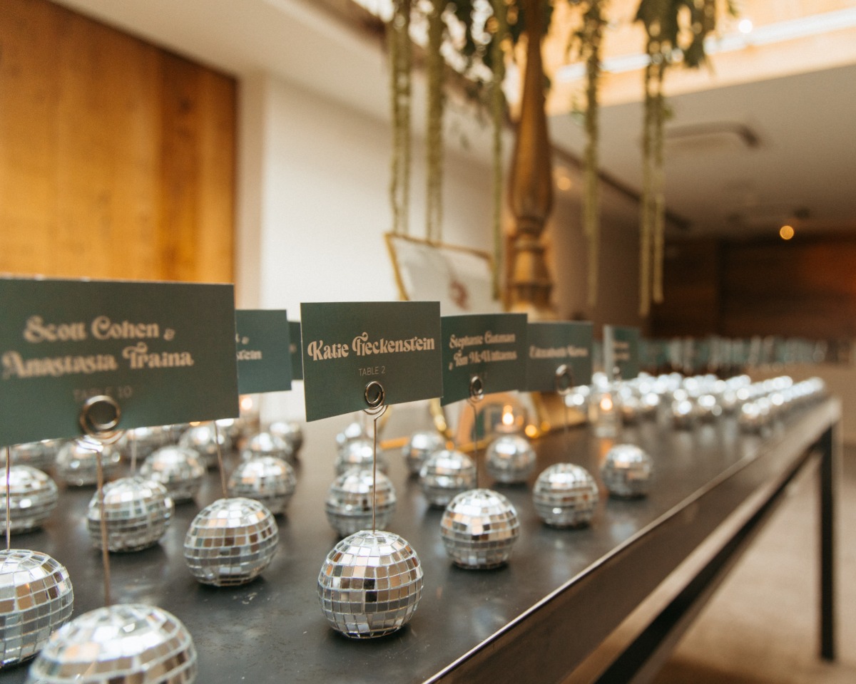 Mini disco ball escort wall with olive green place cards 