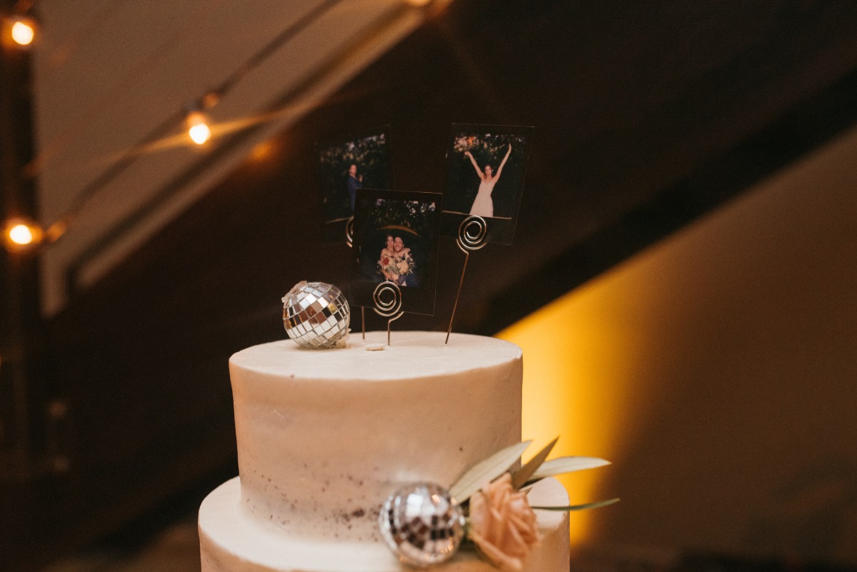 Instax photos with metal holder on top of wedding cake