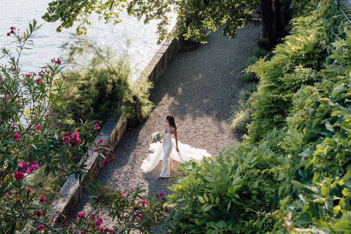bride walks in garden along lake como
