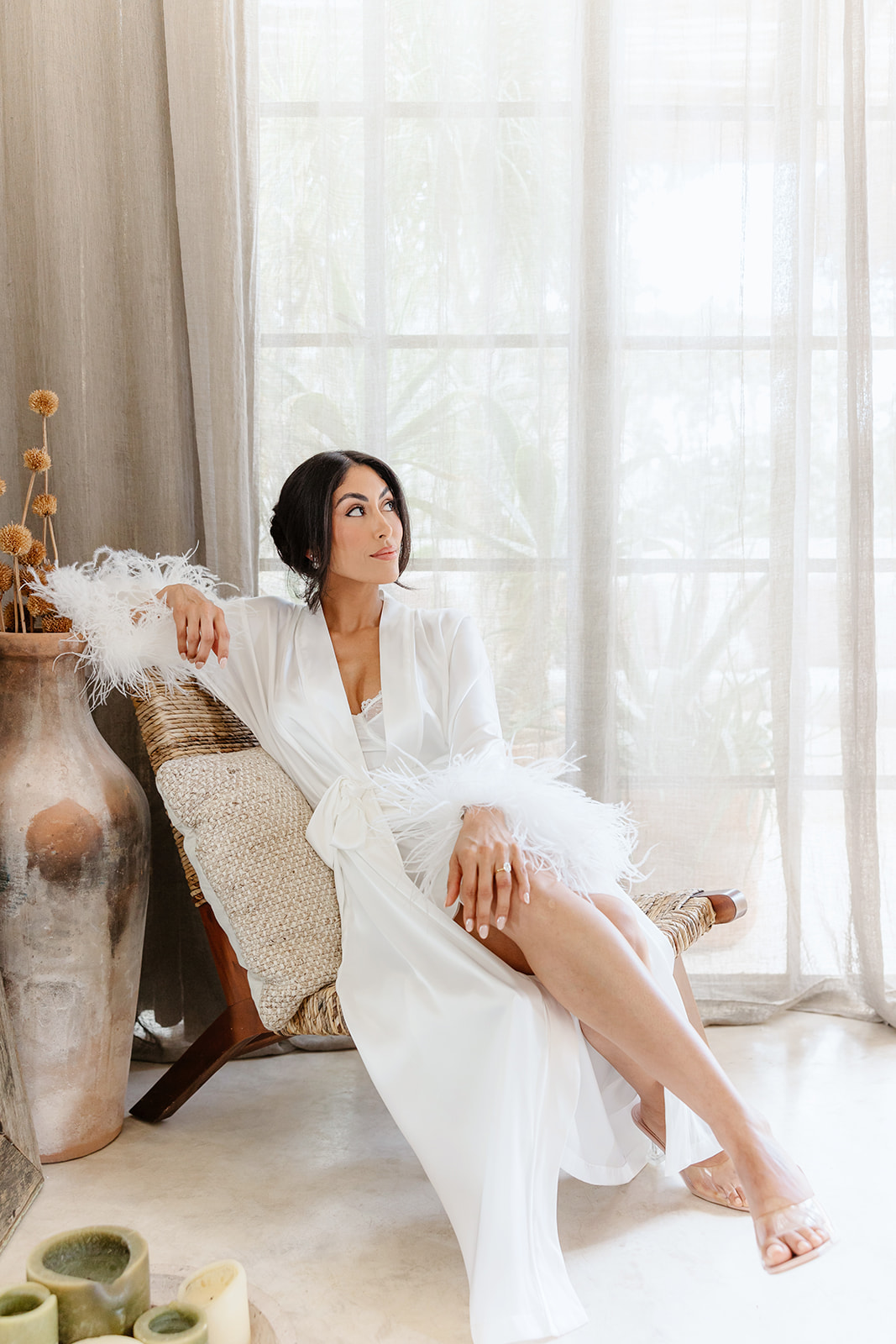 Beautiful luxury bride in feathered silk white robe 