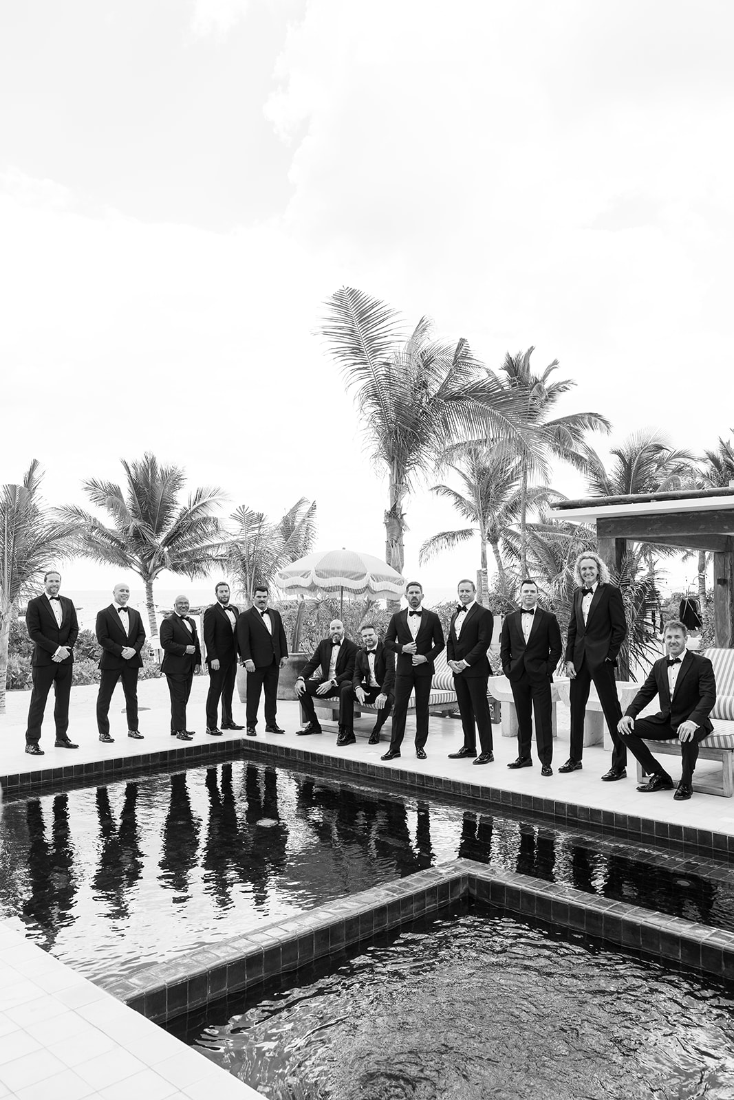 Groomsmen in classic black tuxedos for modern Tulum wedding 