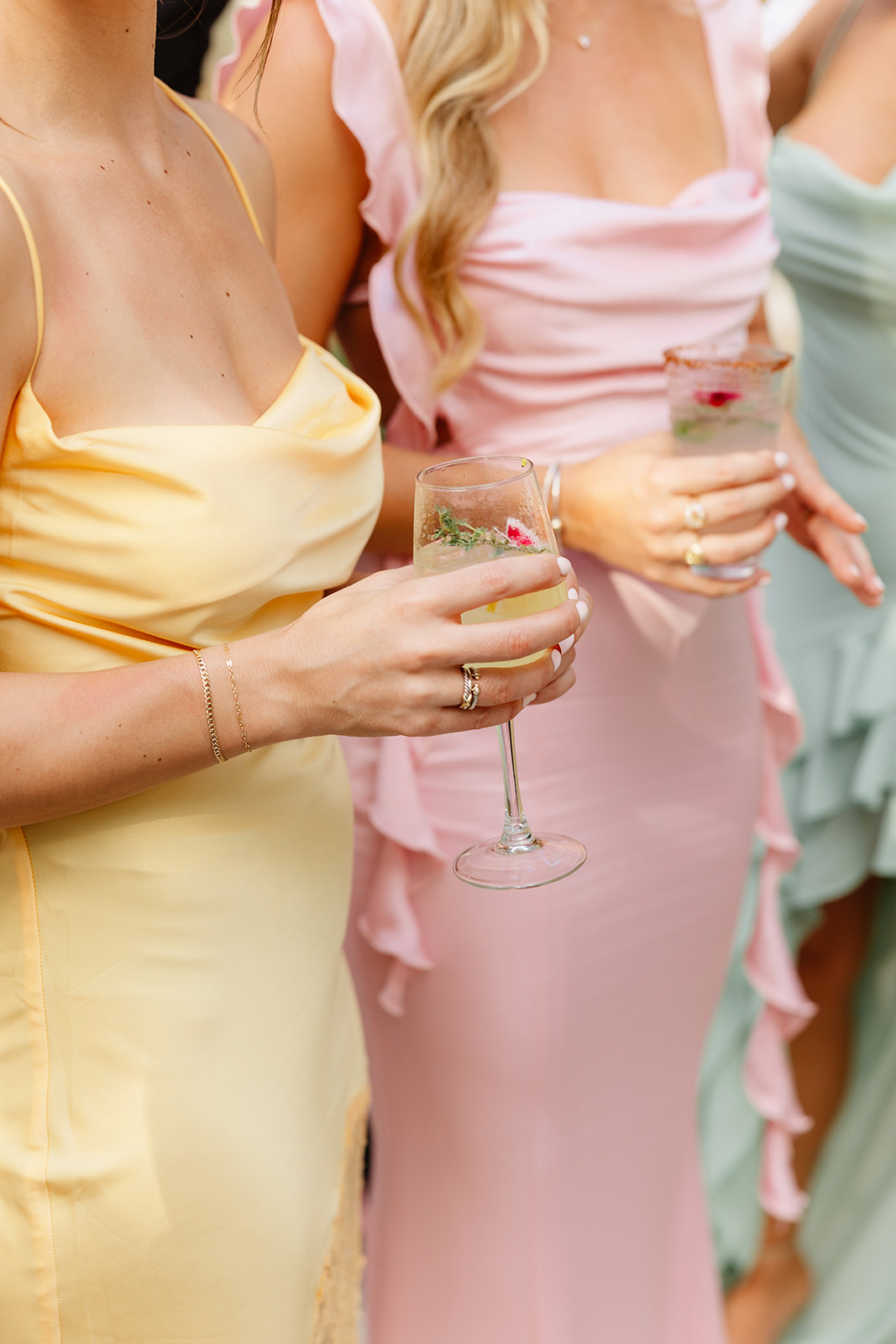 Pastel bridesmaids holding refreshing citrus wedding cocktails