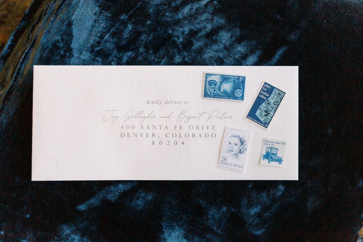 Wedding invitation envelope with blue vintage postage stamps