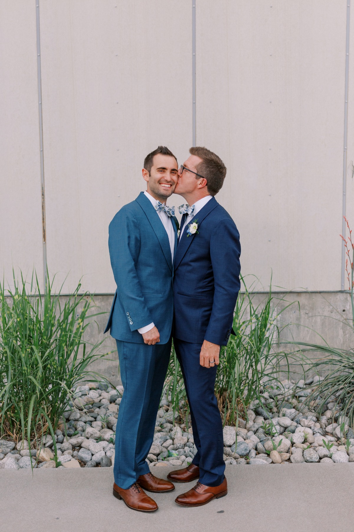 Grooms kissing cheeks at Space Gallery wedding in Denver