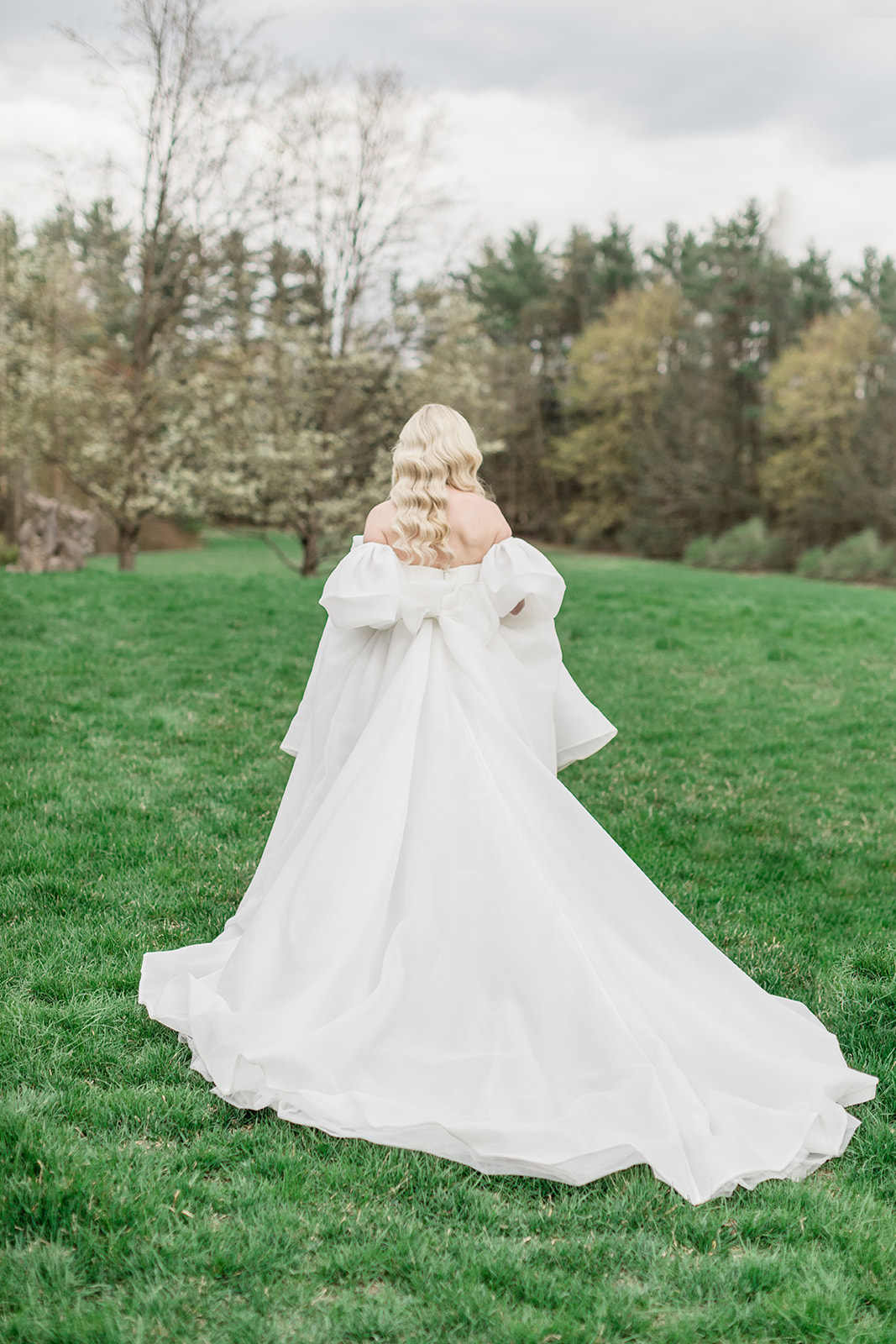 Billowing timeless wedding dress with sleeves and back bow