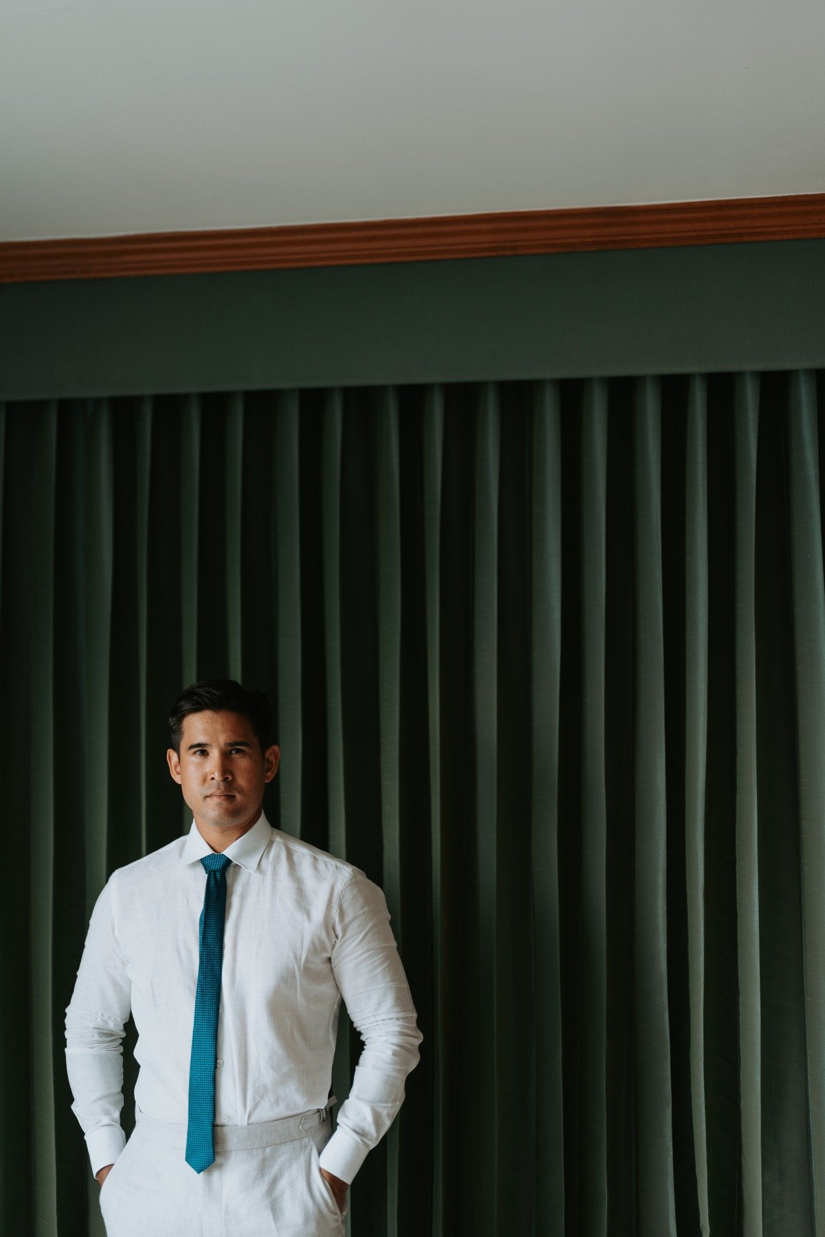 groom in blue gray linen suit with dark teal tie