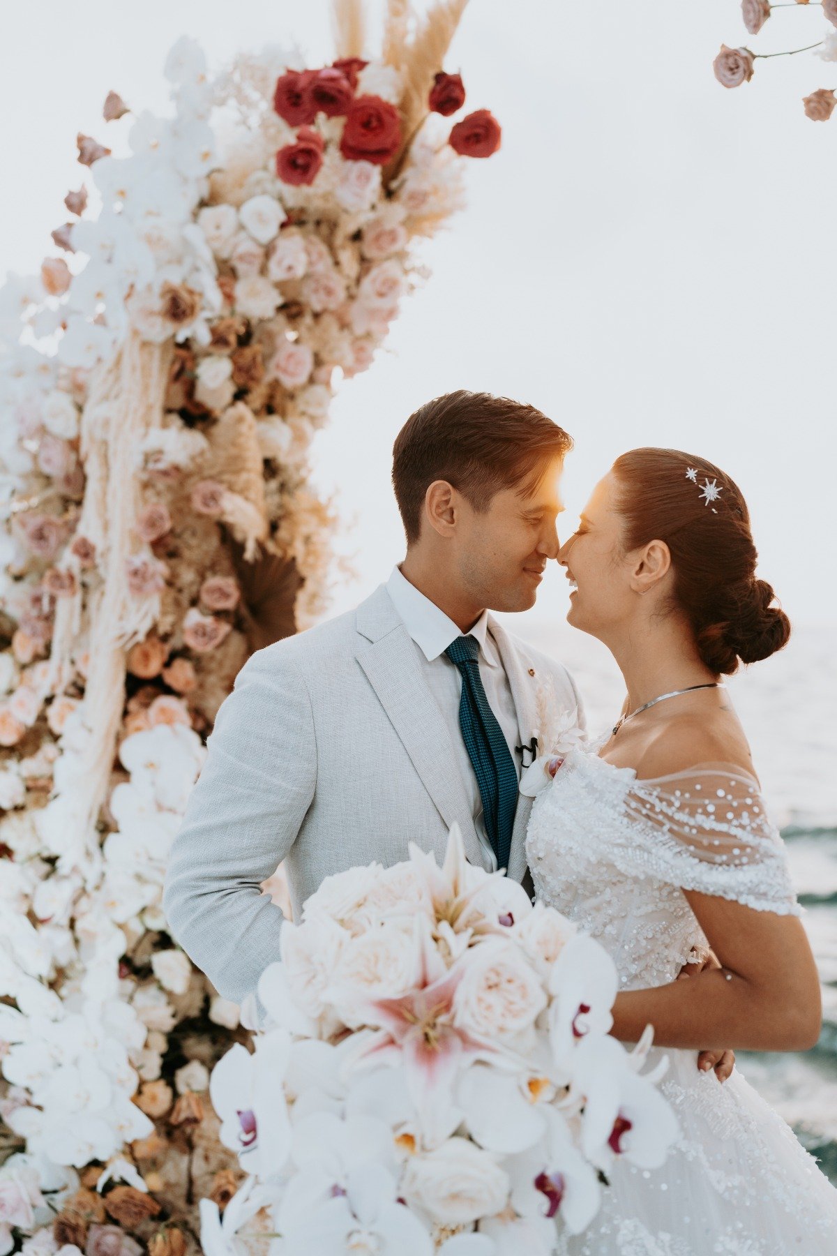 bride in tulle and sequin wedding gown with star pins in hair and groom in linen suit