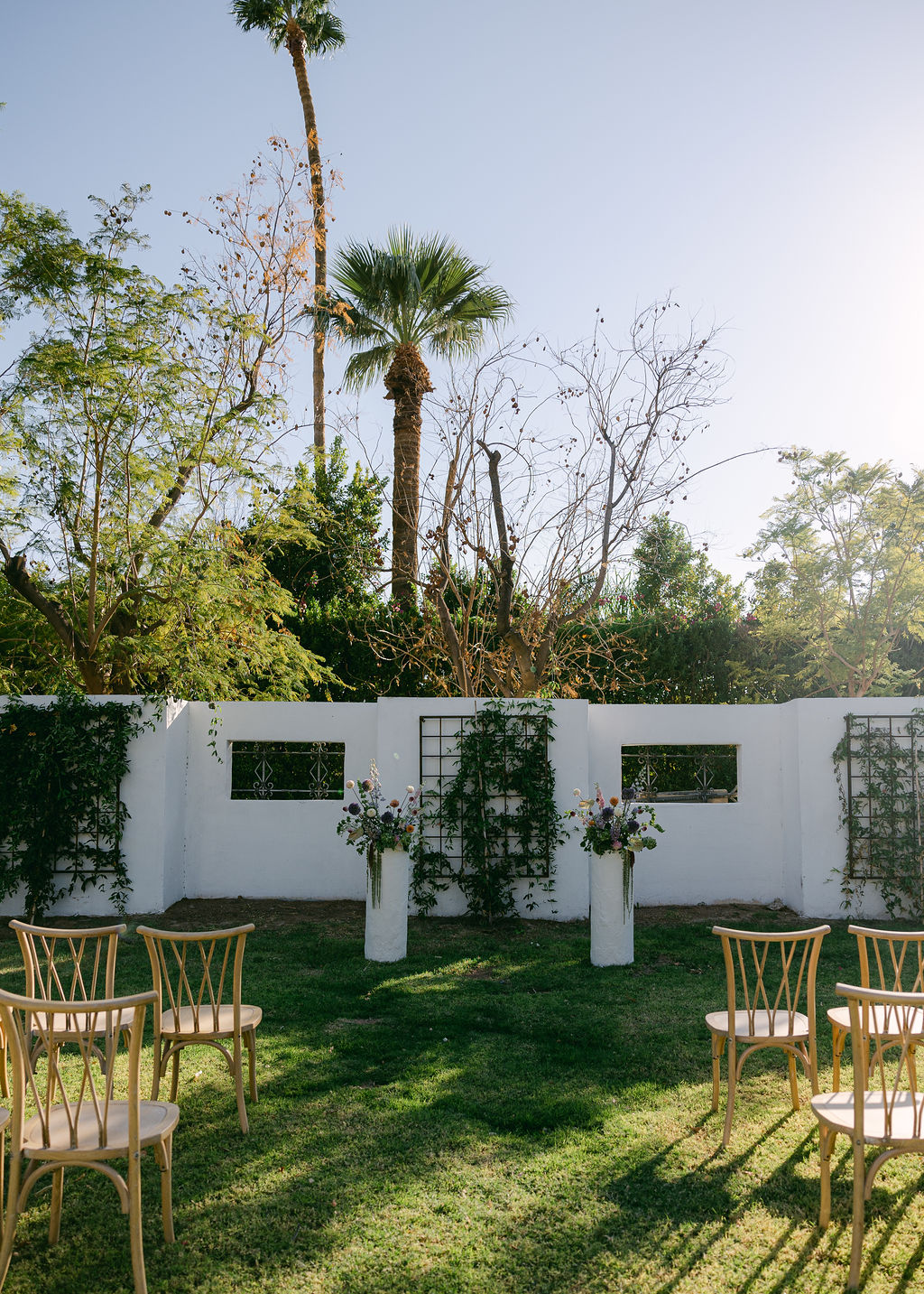 outdoor wedding ceremony with greenery wall backdrop