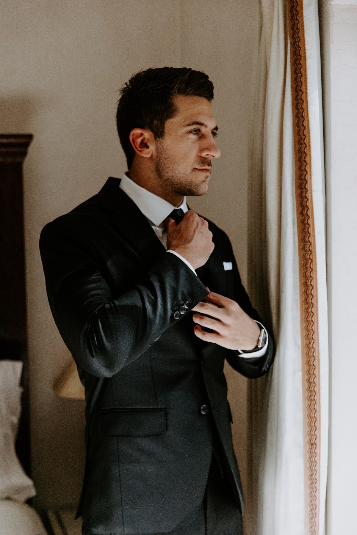 groom in black suit with black tie