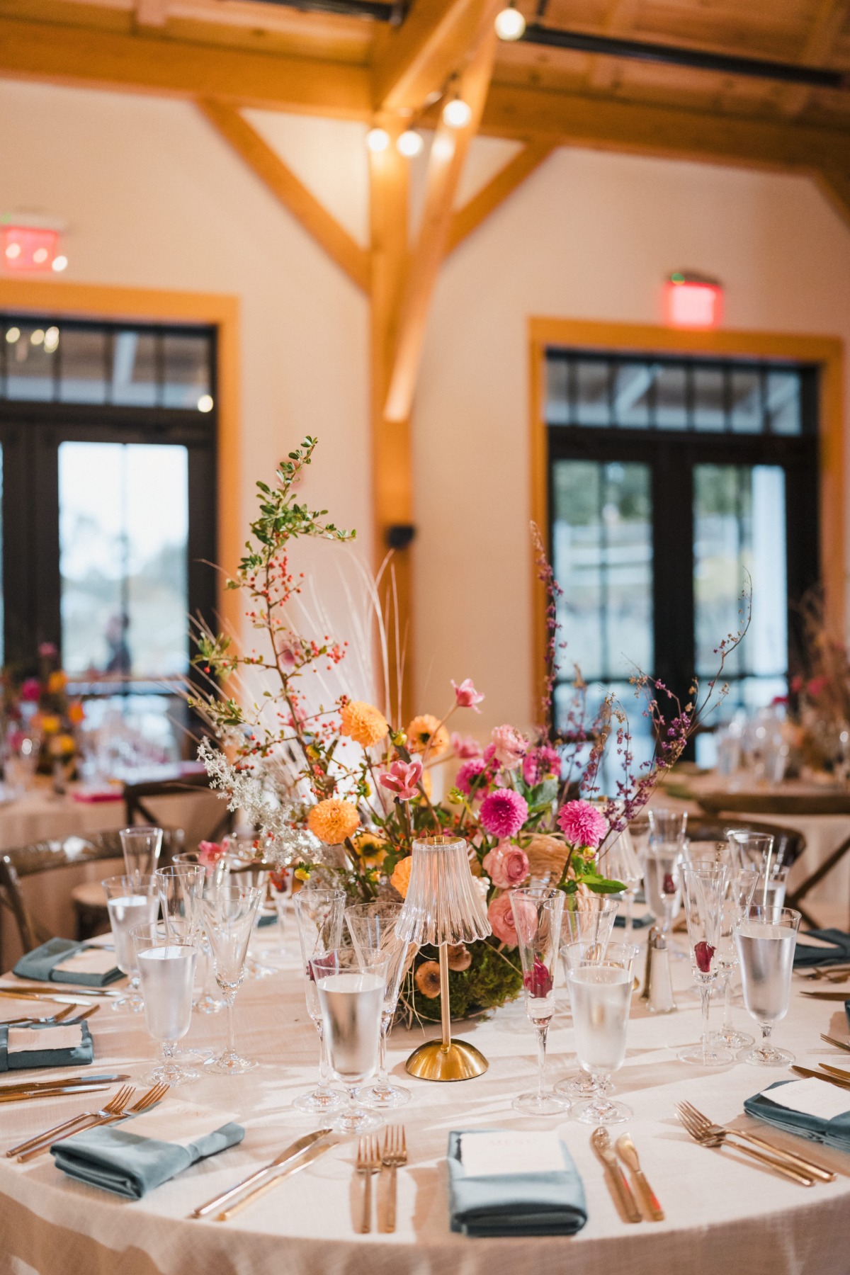colorful woodsy centerpieces with pops of blue linens