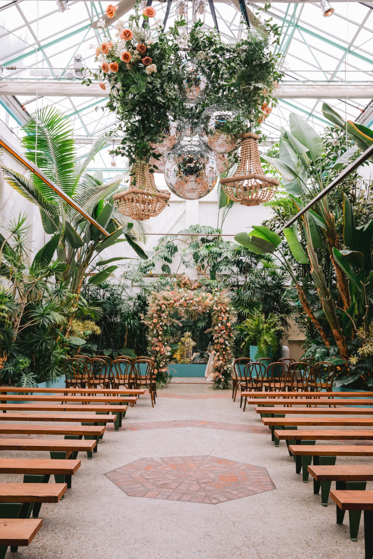 Greenhouse wedding venue with disco balls and flower arch