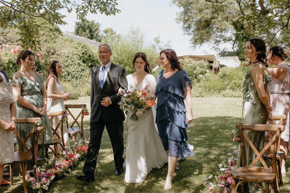 mom and dad walking bride down the aisle