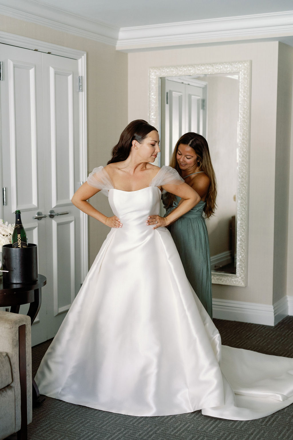 bridesmaid helping bride into dress photo idea