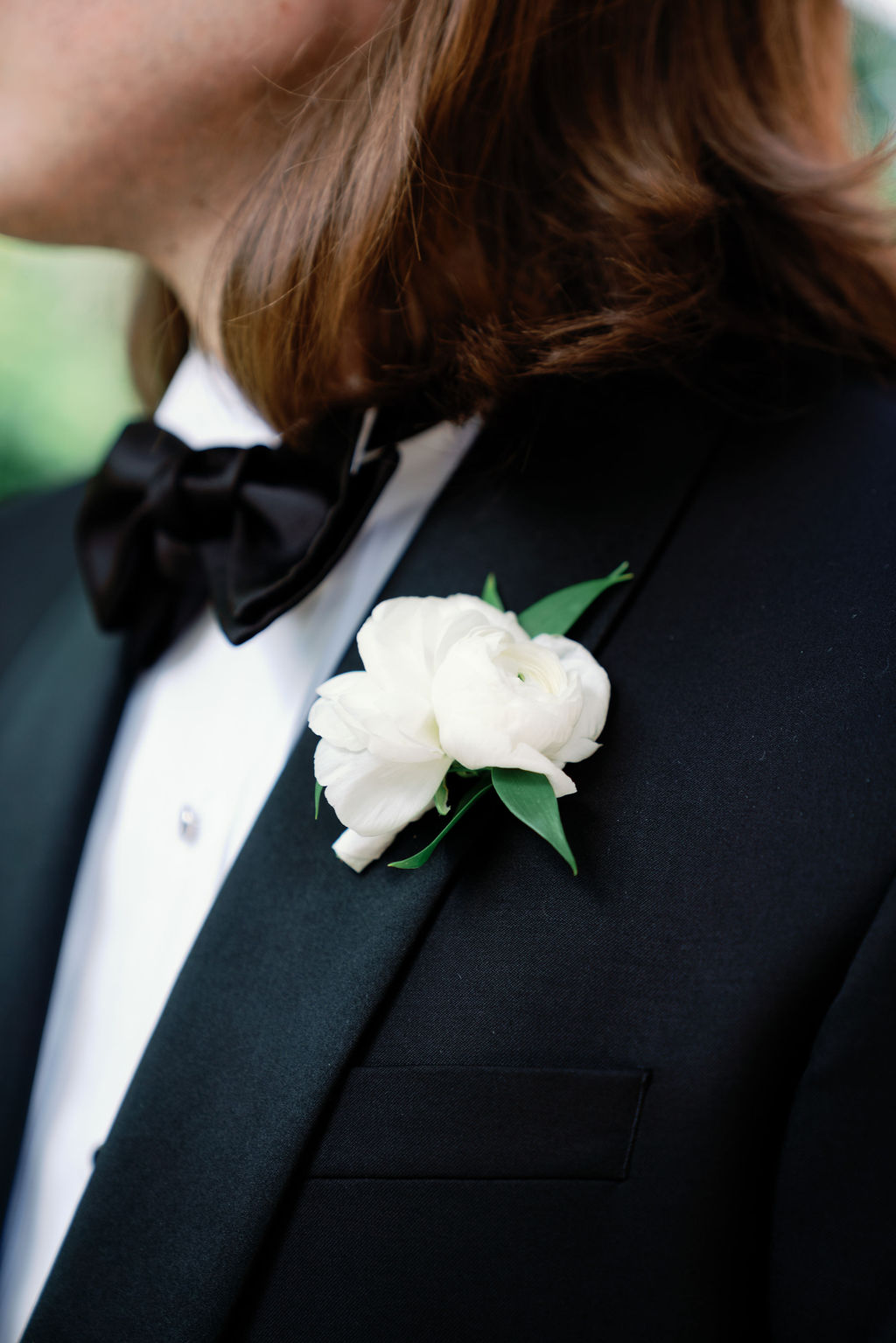 black tuxedo with a white rose boutonnière