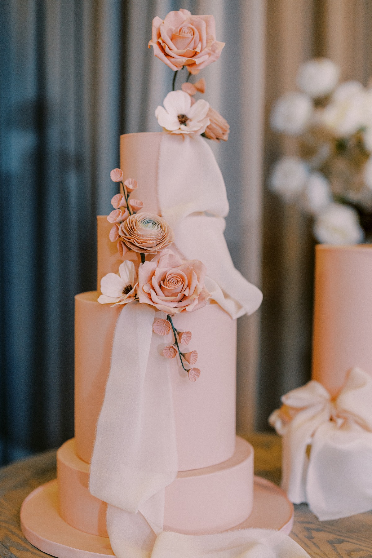 pink wedding cake with pink flowers and draped fondant