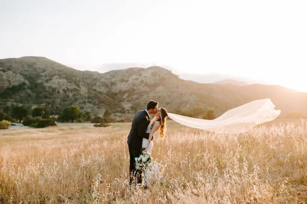 Couple Kissing in Field During Sunset