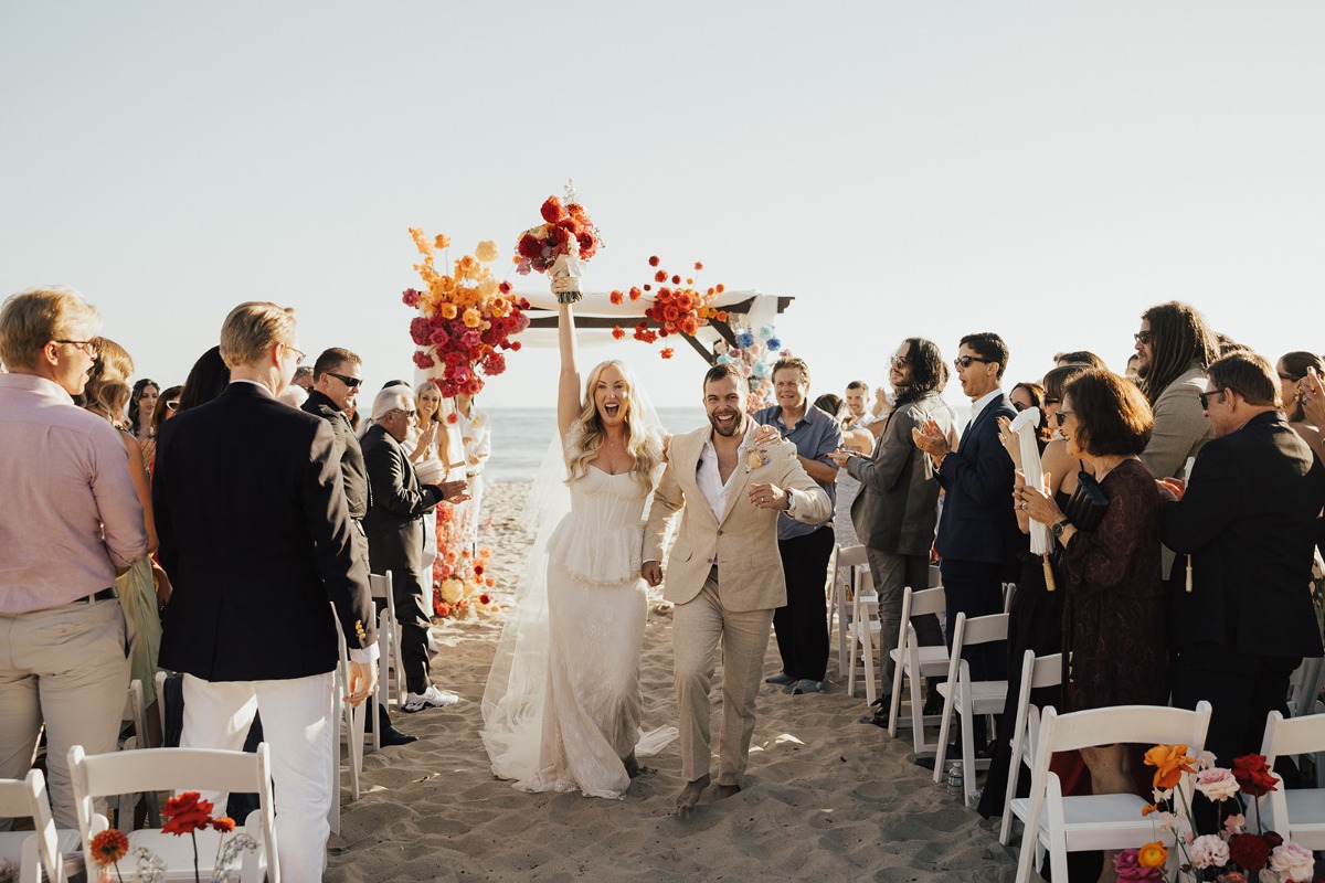bride and groom leaving beach wedding ceremony