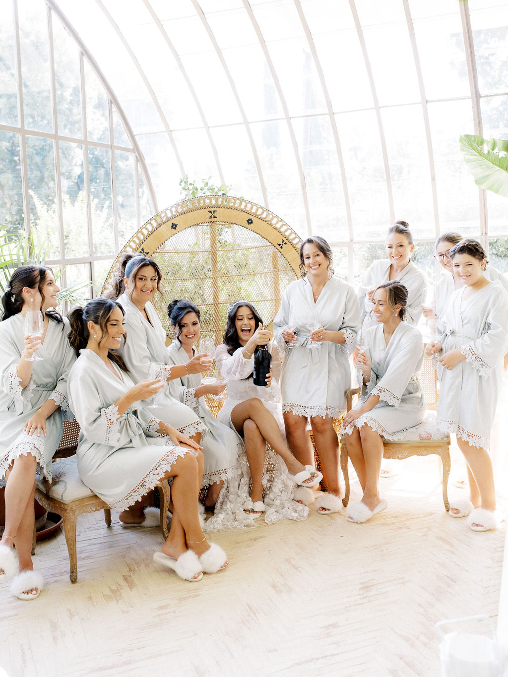 bride and bridesmaids share champagne toast in greenhouse