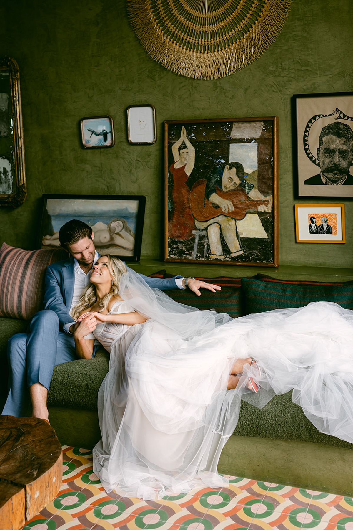 couple laying a vintage green couch