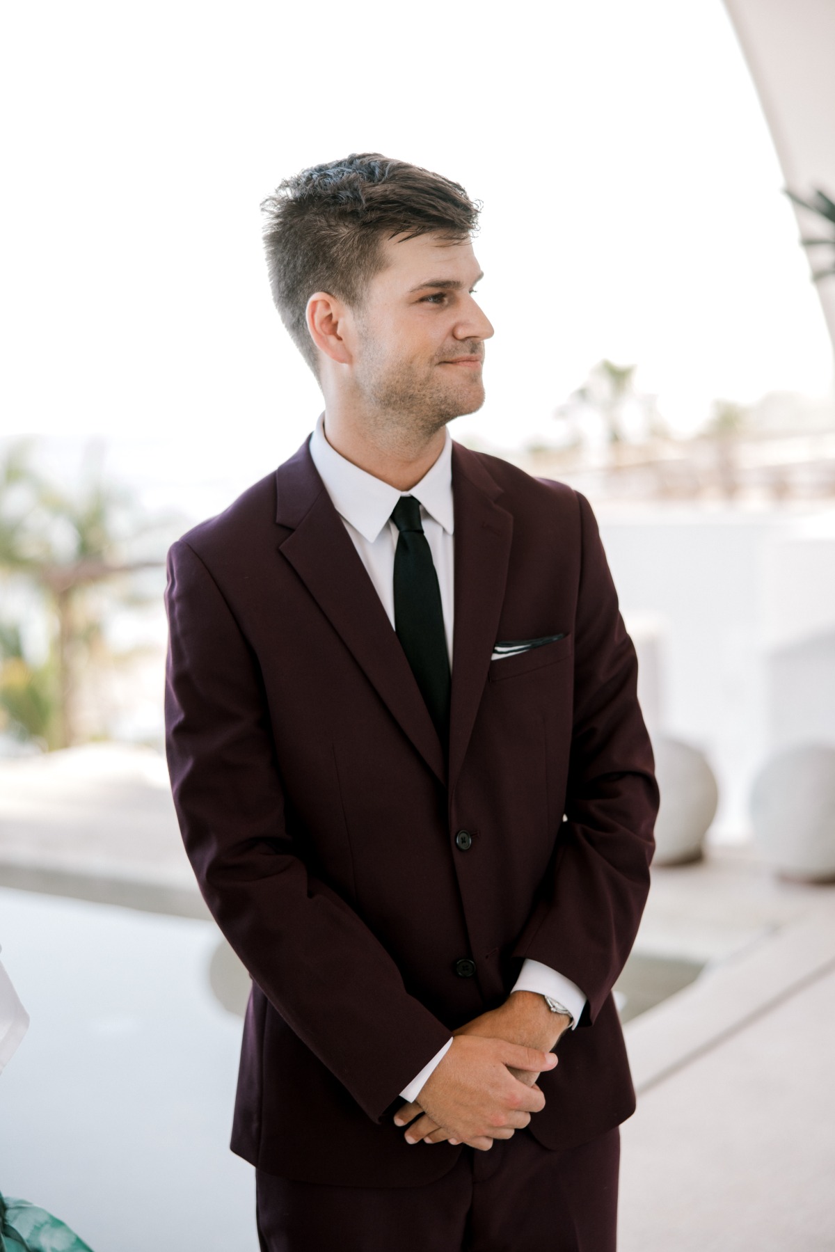 groom in burgundy suit