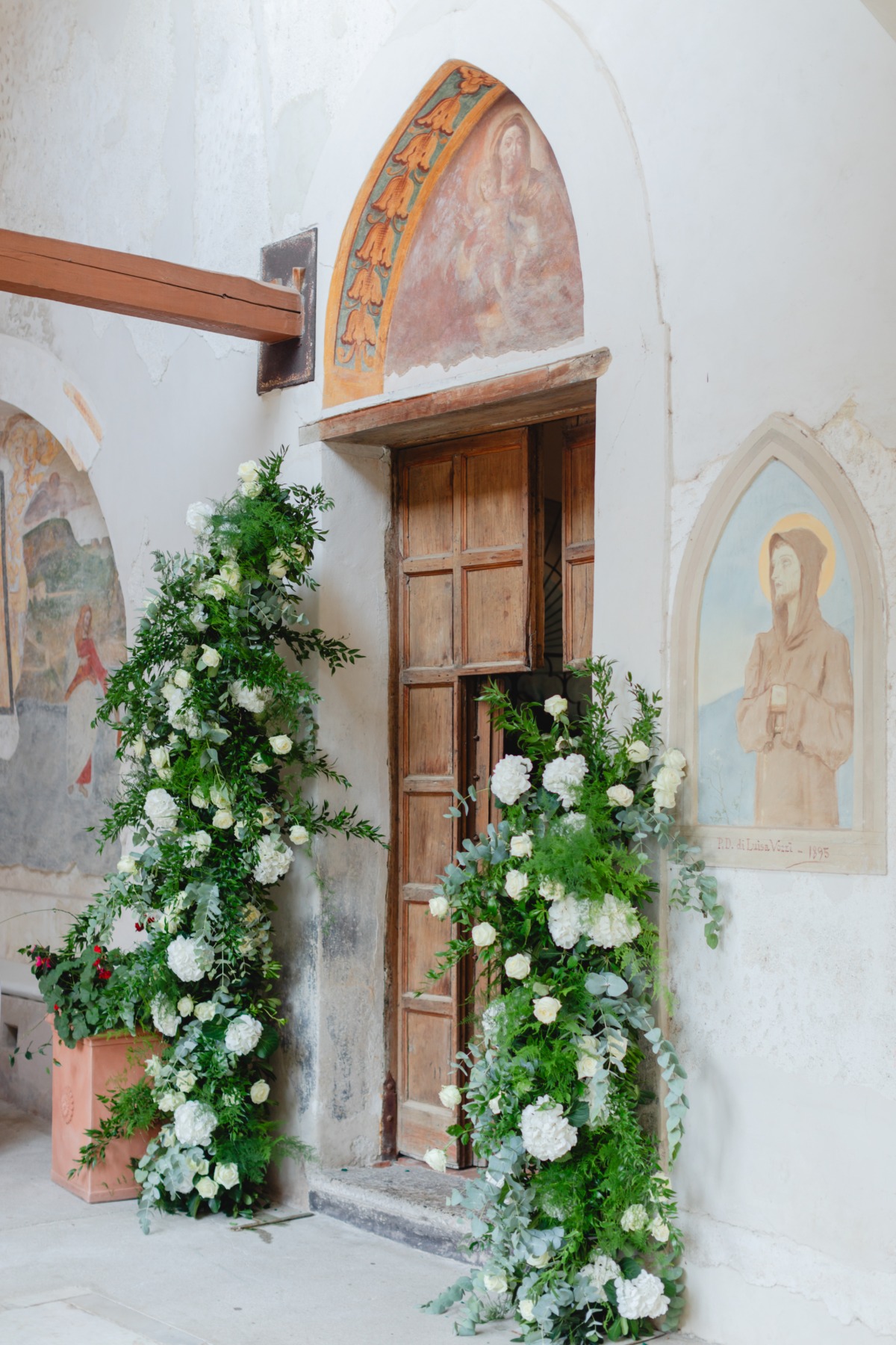 asymmetrical floral columns with white roses and greenery