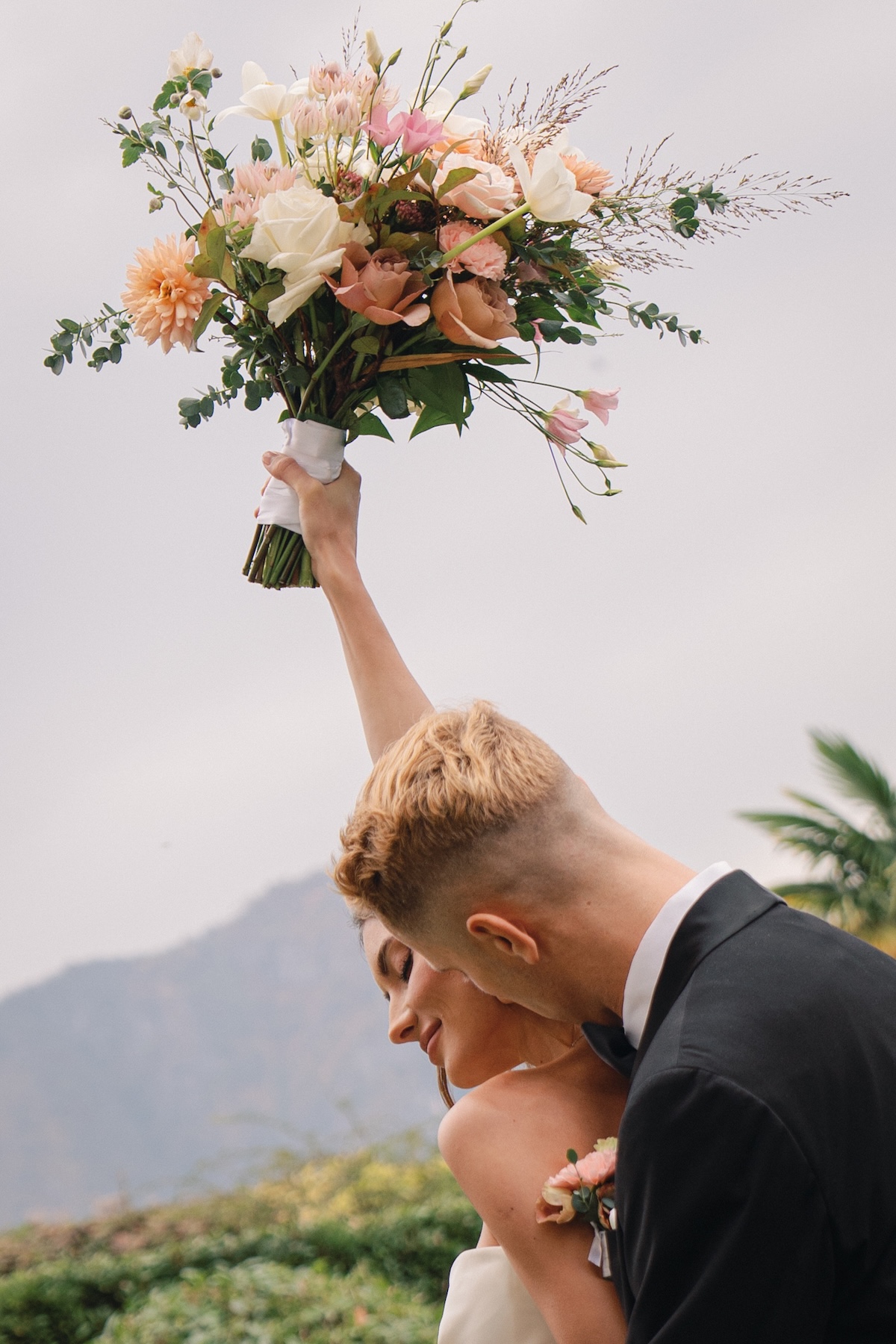 couple laughing and holding a bouquet