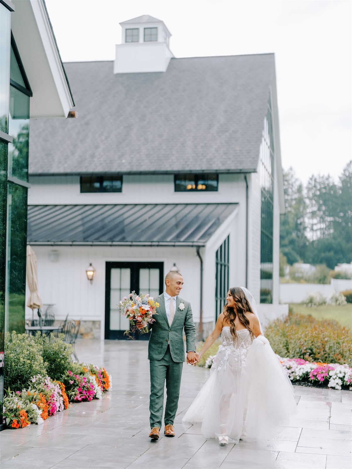 Couple walking outside venue with lots of colorful flowers