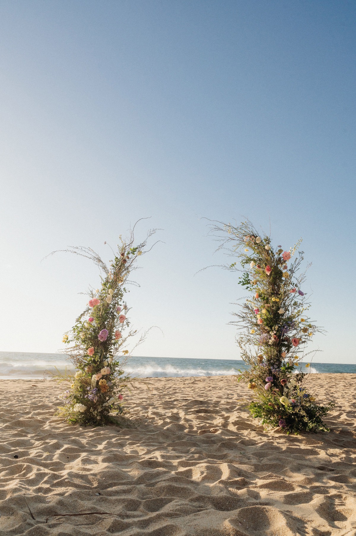 whimsical wildflower arch on beach