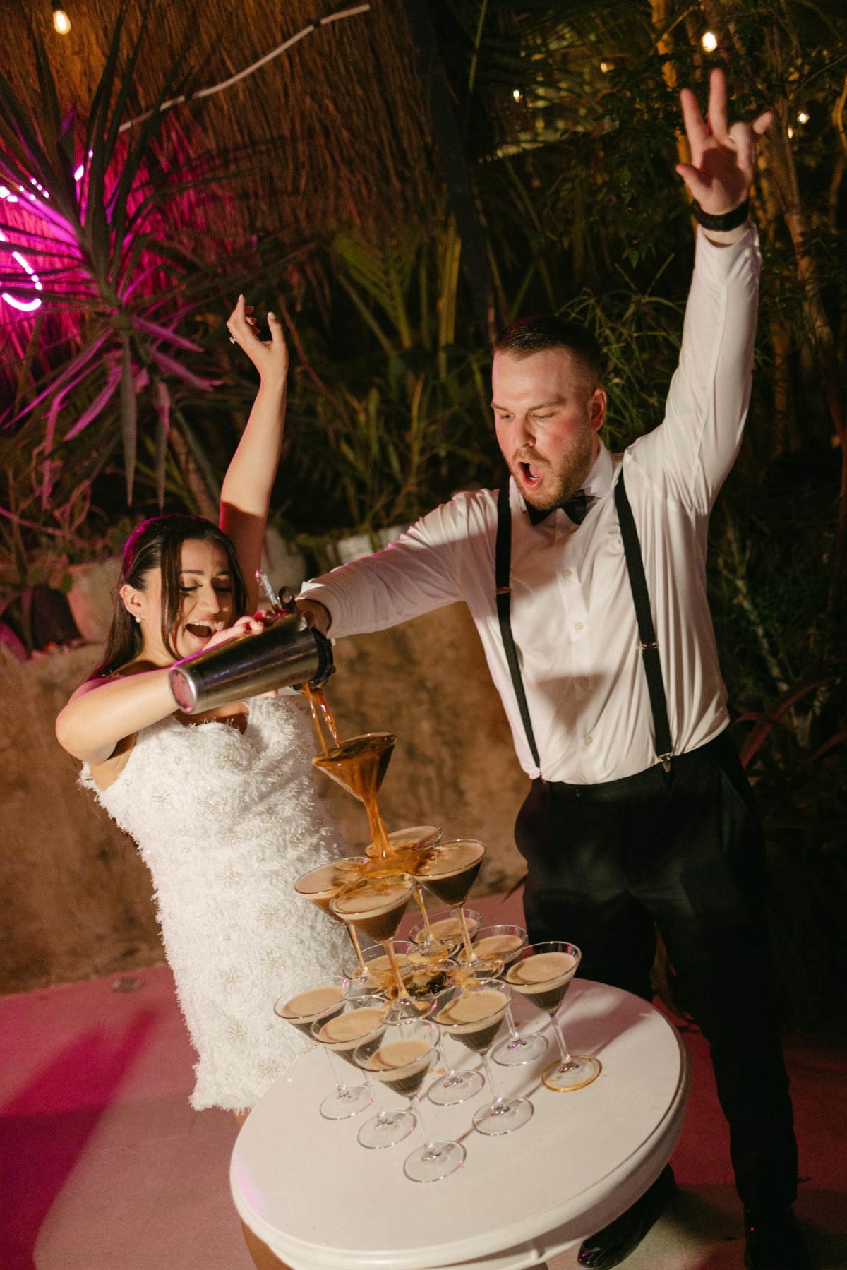 bride and groom pour espresso martini tower