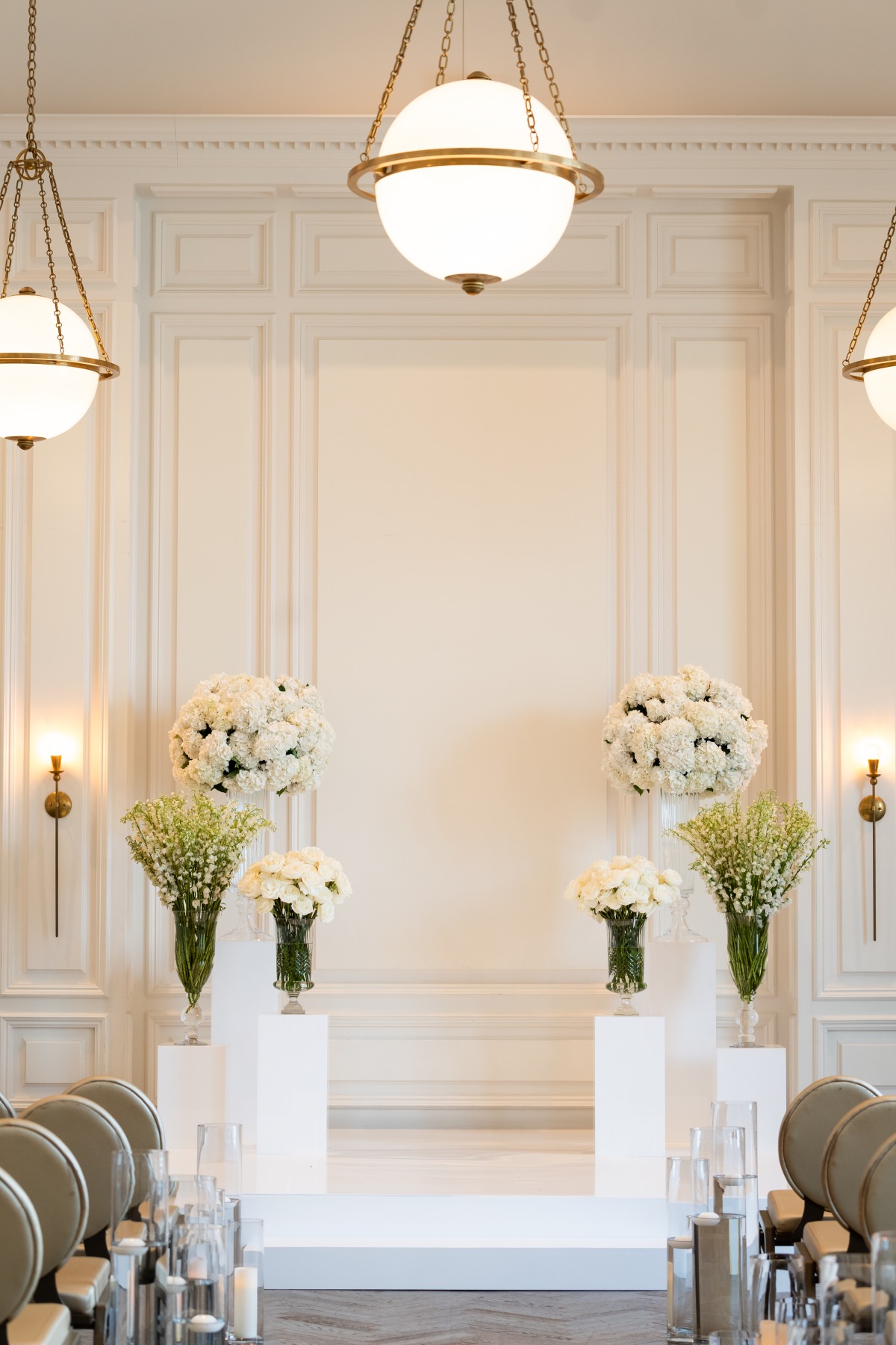 white floral arrangements on white pillars