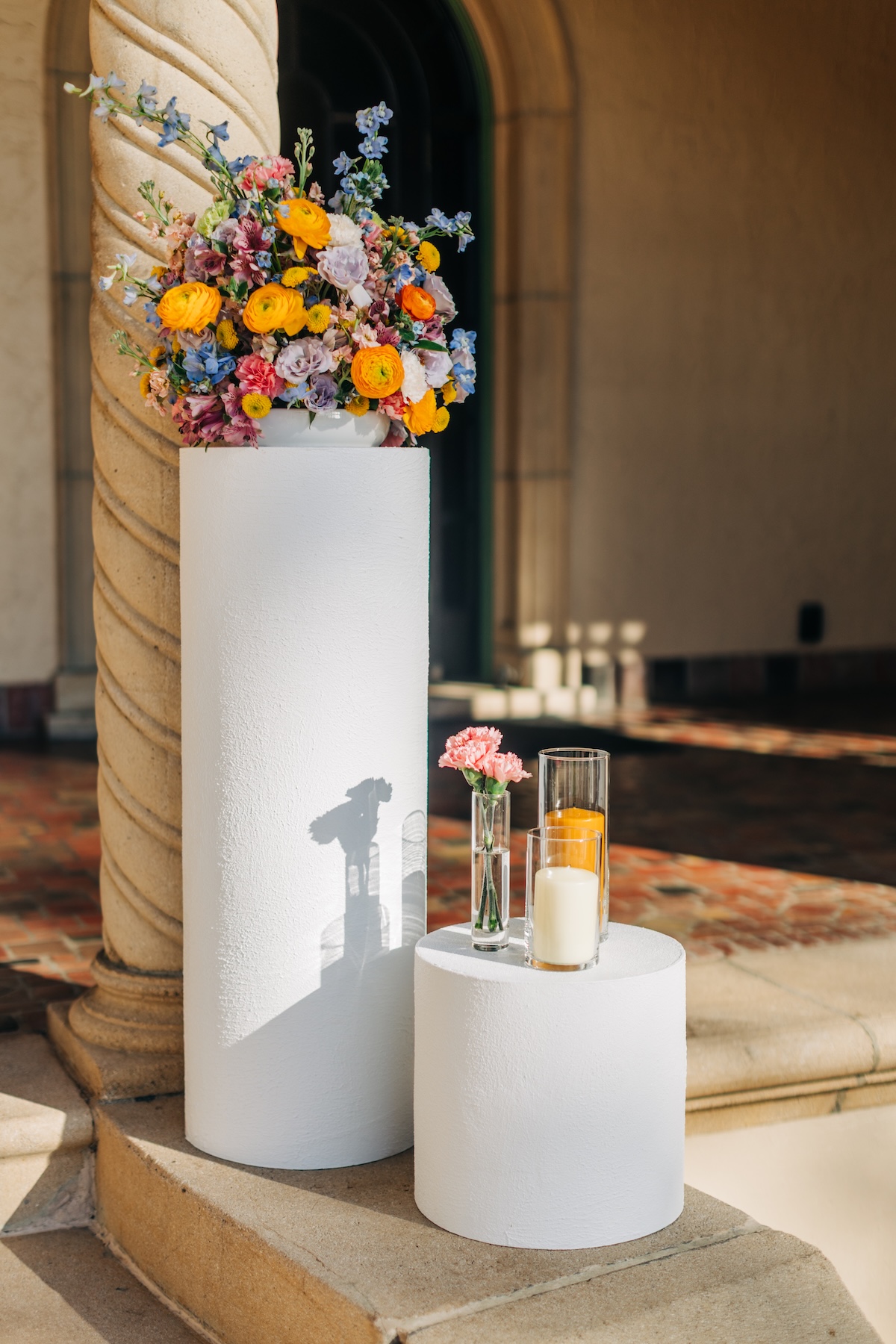 rainbow wedding ceremony floral arrangements with yellow ranunculus