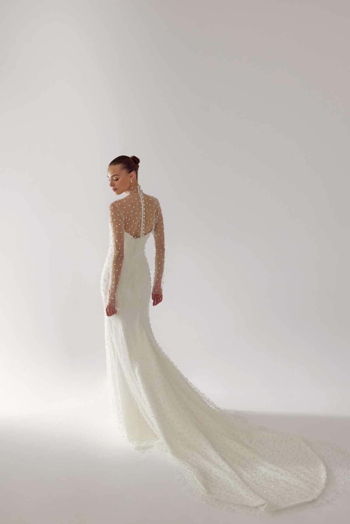 back view of bride in gown with long train and pearls