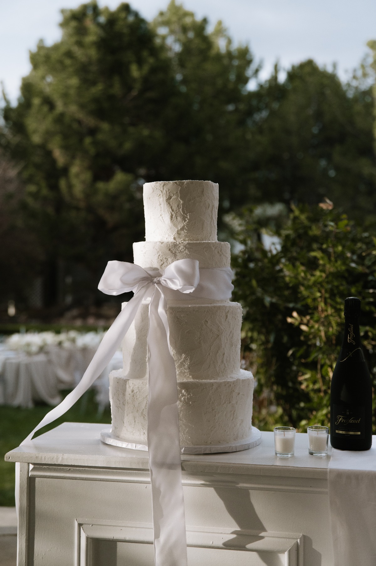 four tiered butter cream wedding cake with bow